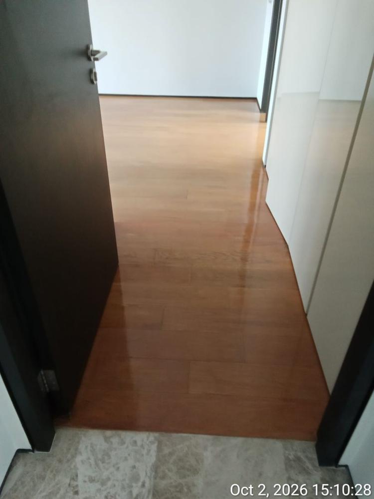 Varnished strip parquet seen through a condo bedroom door