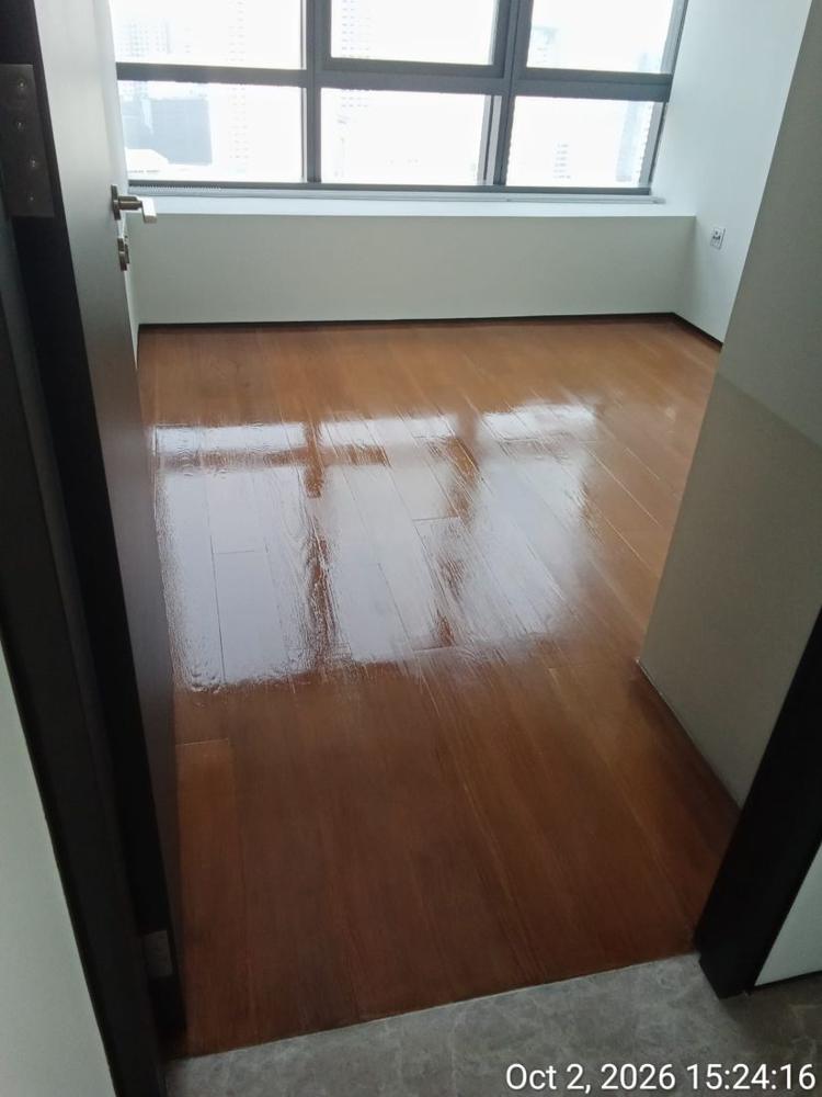 High-gloss strip parquet reflecting the window in a condo