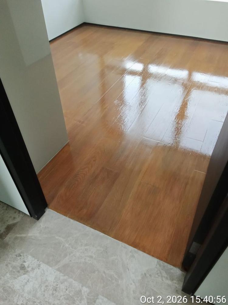 Varnished strip parquet meeting a marble threshold