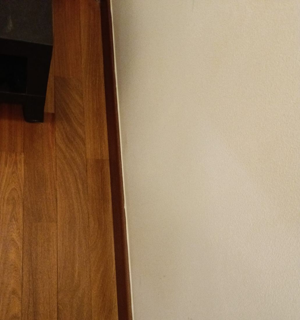 Teak strip floor meeting the skirting in a condo