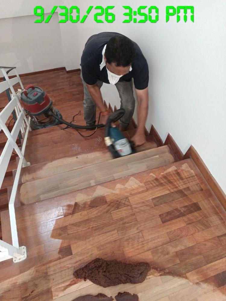 Technician hand-sanding a timber stair tread