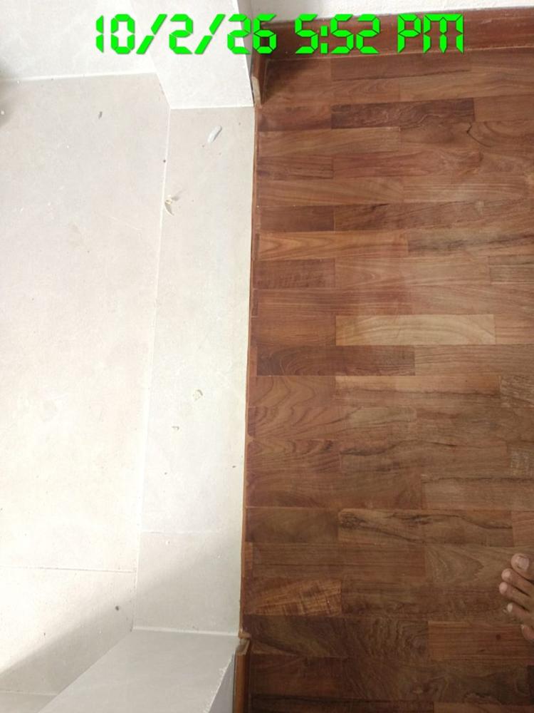 Clean edge where finished parquet meets marble tiles