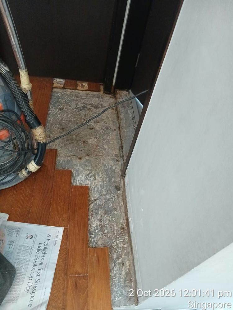 Strip parquet lifted at a doorway, exposing the screed