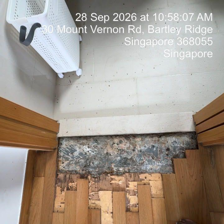 Water-damaged parquet removed at a bathroom doorway in a condo