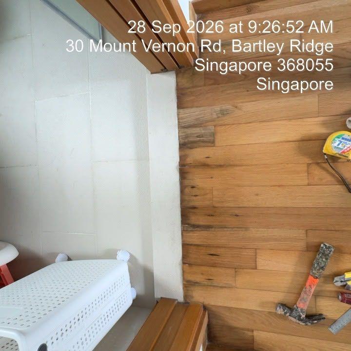 Blackened, water-stained parquet strips by a bathroom door